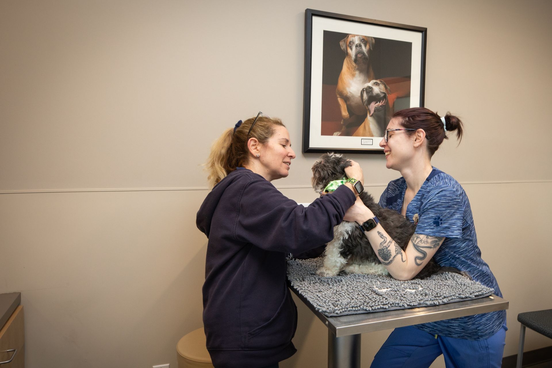 a couple of women that are petting a dog