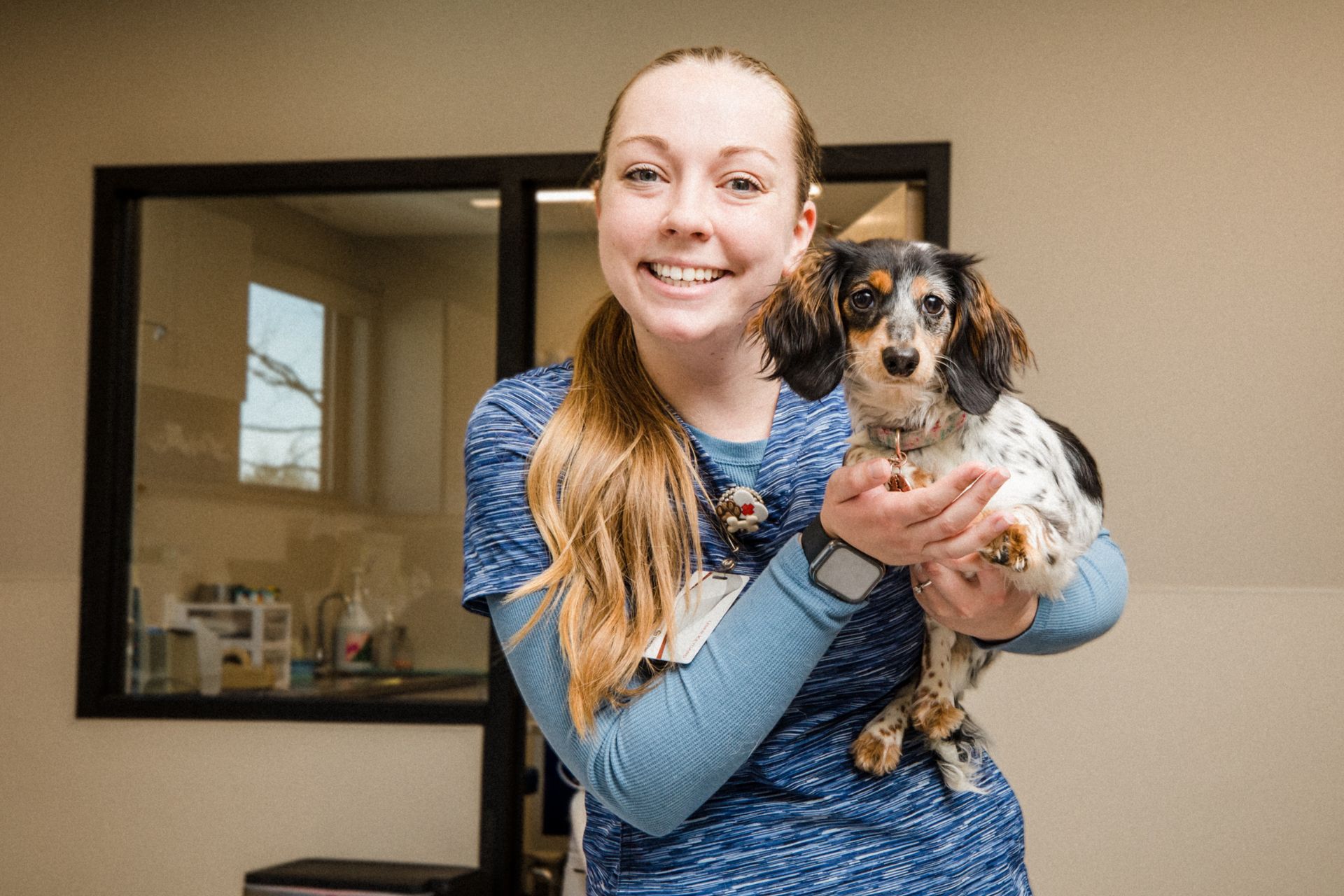 a woman holding a small dog in her arms