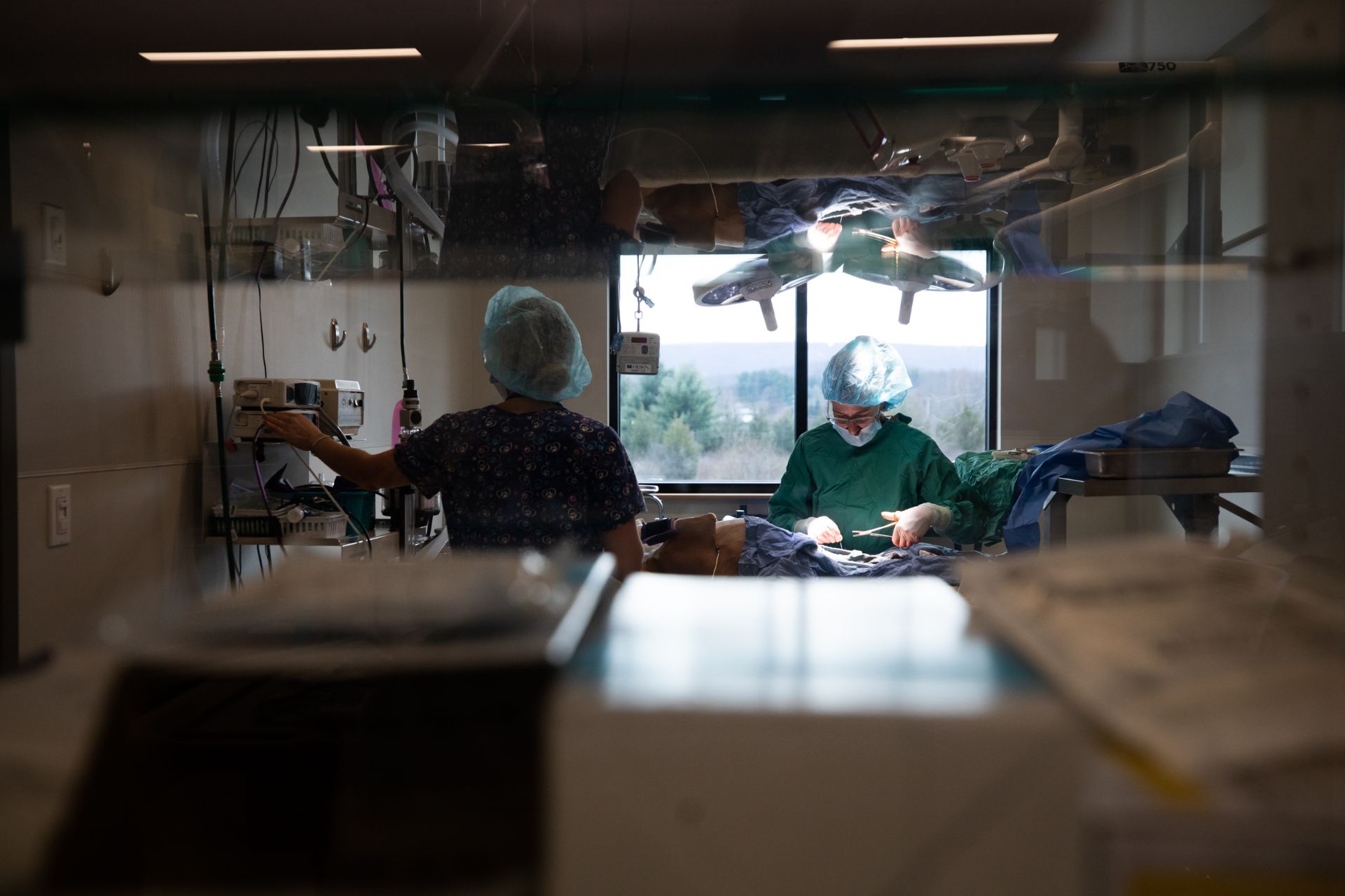 A surgeon, equipped with surgical tools, operates in operating room